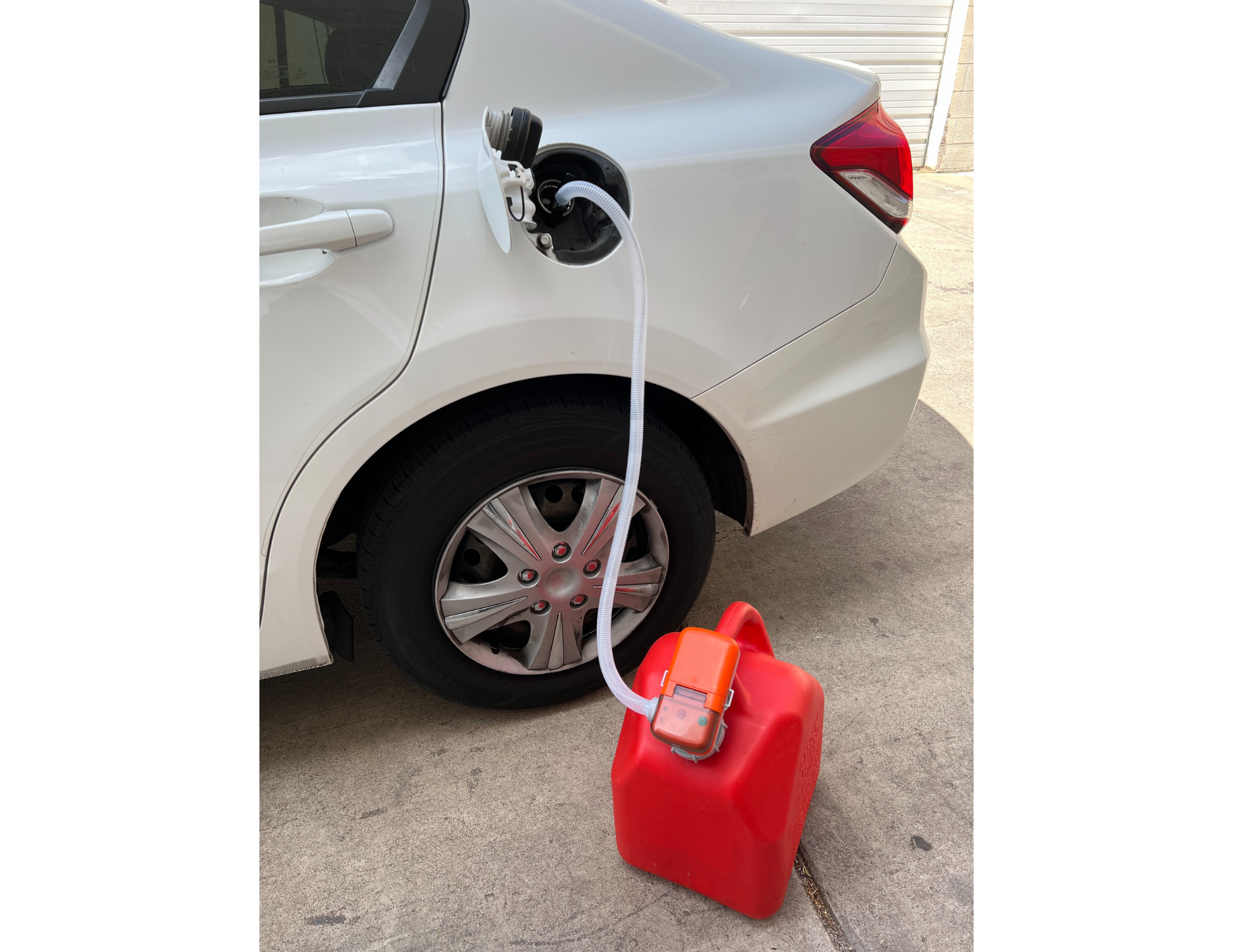 Battery pump by FlowJoe transferring fuel from white car gasoline tank into red can
