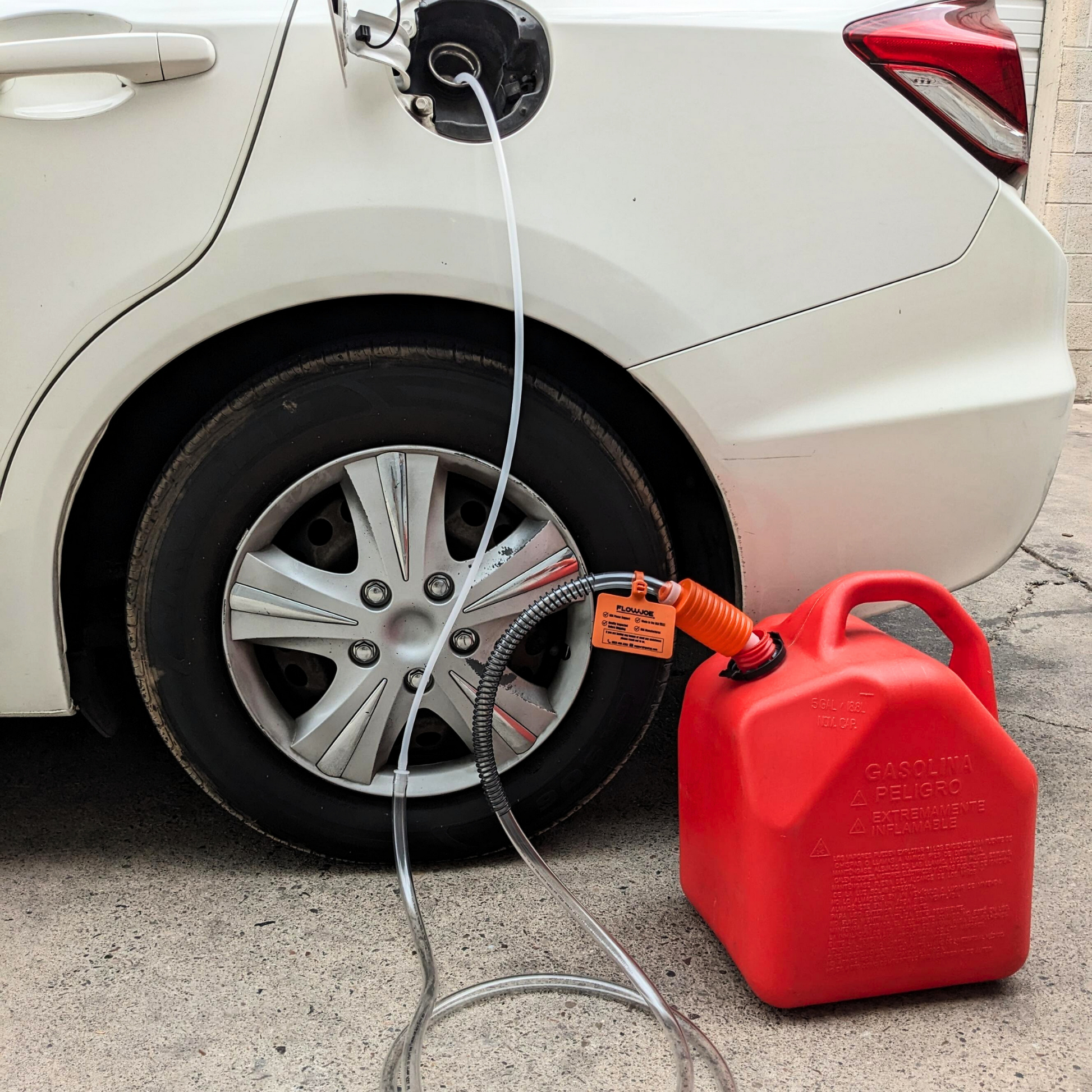 Handy Pump manual fuel transfer siphon moving gasoline from white car to red gas can 