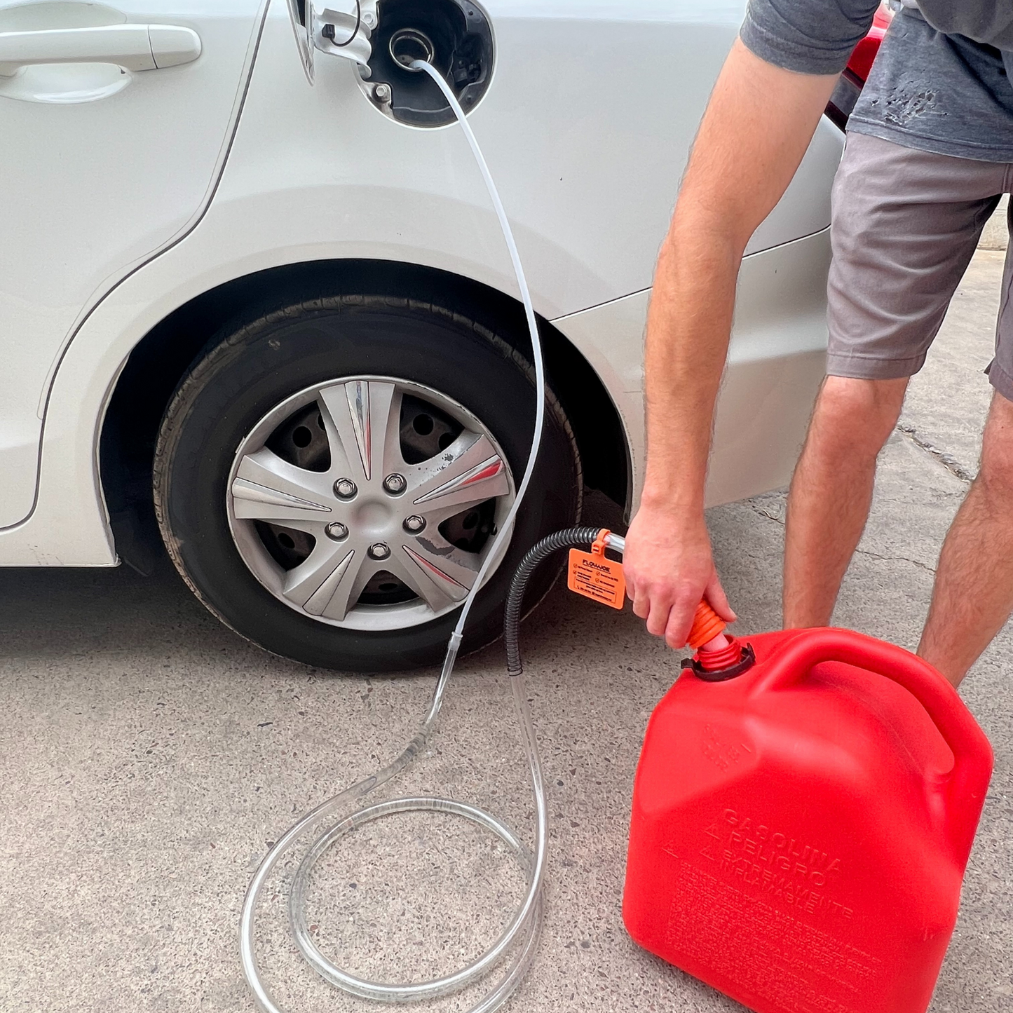 Man holding Handy Pump moving fuel from car to gas can 