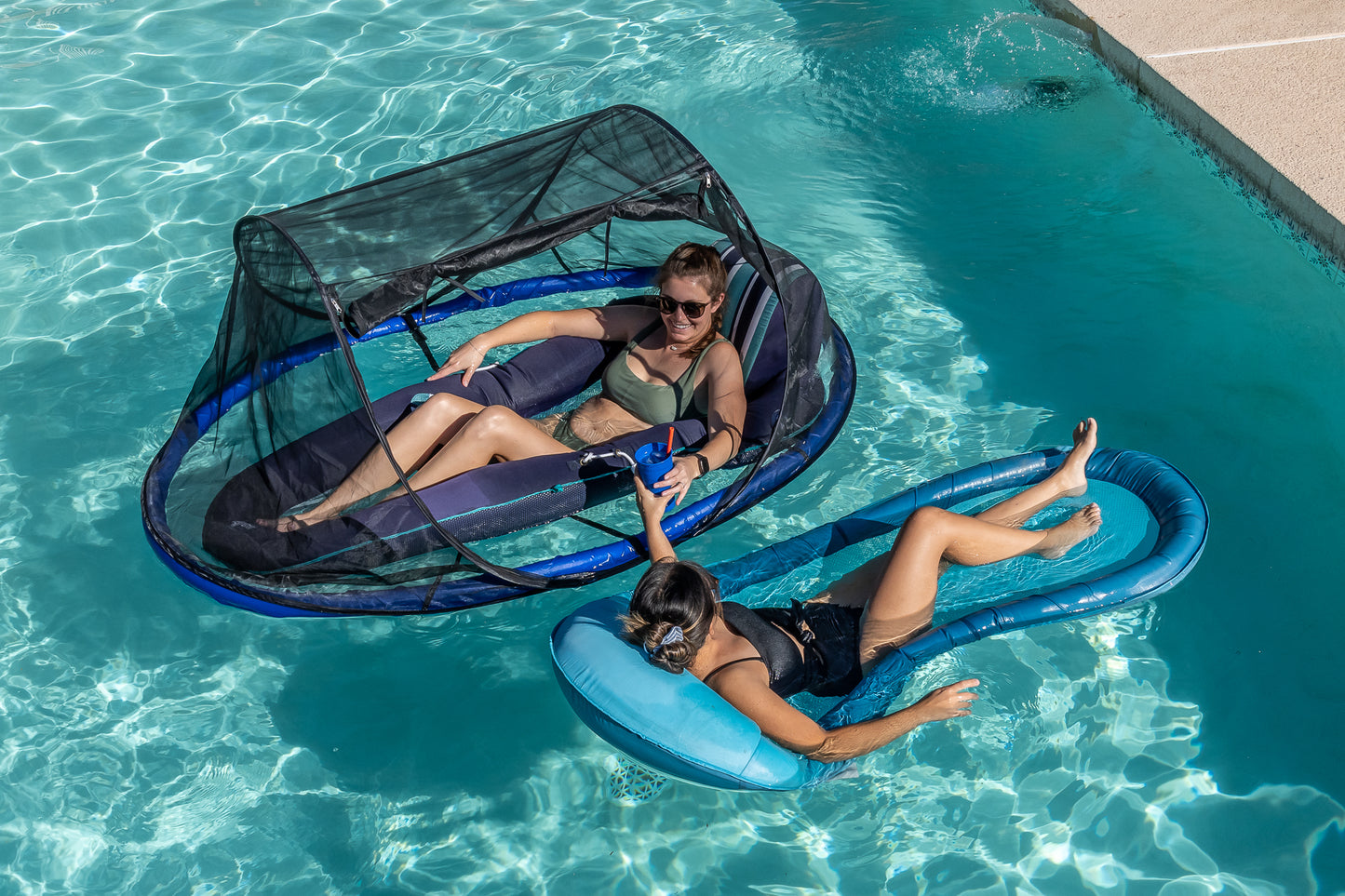 Two girls on pool floats, one with Pest Awaysis being shielded from sunlight and disruptive bugs.