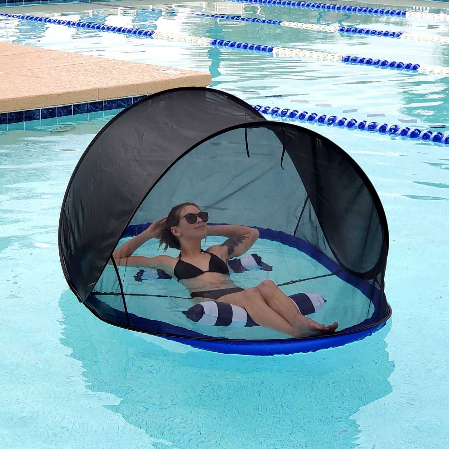 Girl in pool enjoying shade from Pest Awaysis floating pool bug net